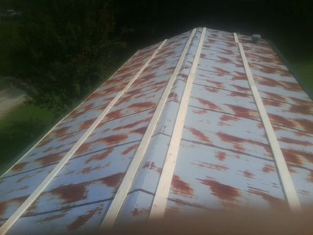 Rusted metal roof panels with new wood purlins before replacement — Storm Damage Roof Repair in Maskell by Roofing Brothers
