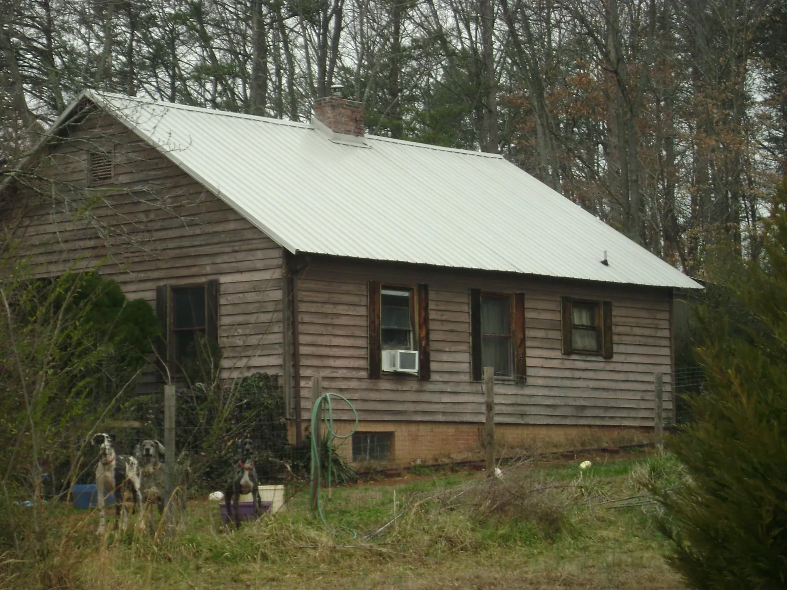 White metal roof on an old wood sided farmhouse, from a Metal Roof Installation job in Maskell